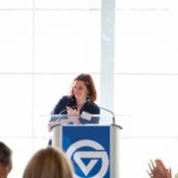 Laura Aikens, VP of Development, speaking at podium